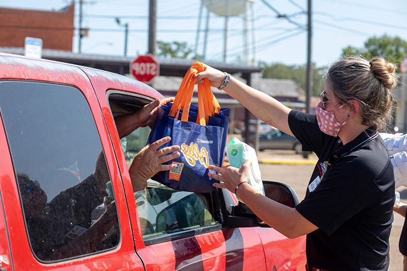 一名拉斐特大学的学生向路易斯安那州一位有需要的居民捐赠食品杂货